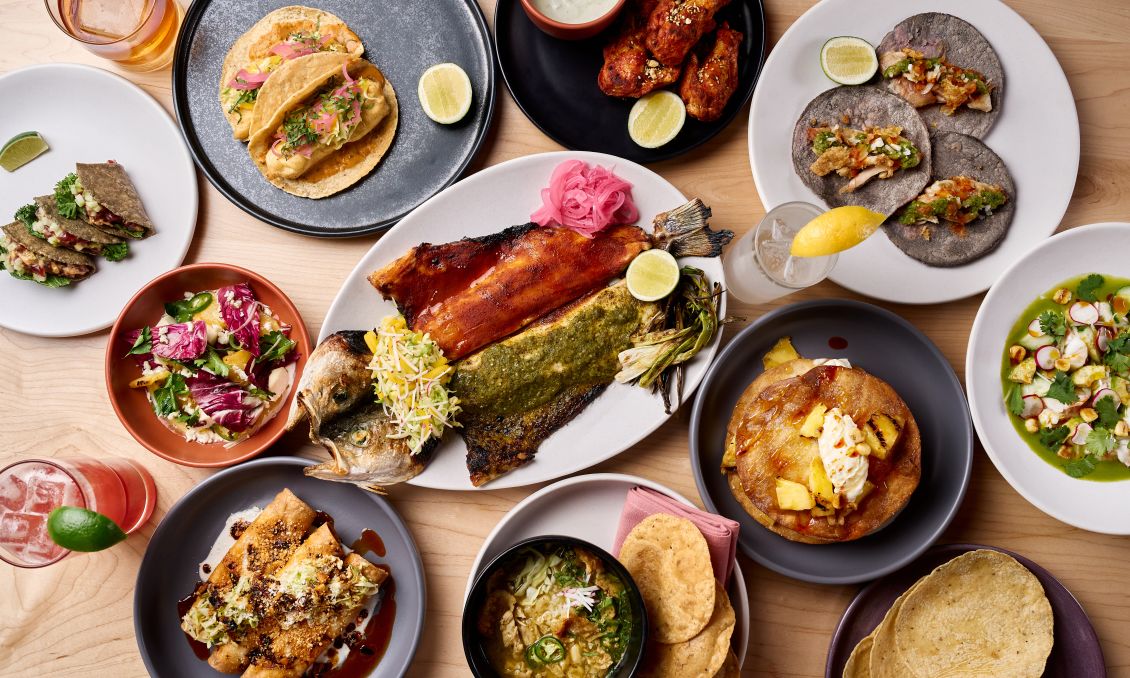 Overhead view of assorted plated dishes featuring fine dining presentations, seasonal ingredients, sauces, and shared plates at a Raleigh restaurant table.